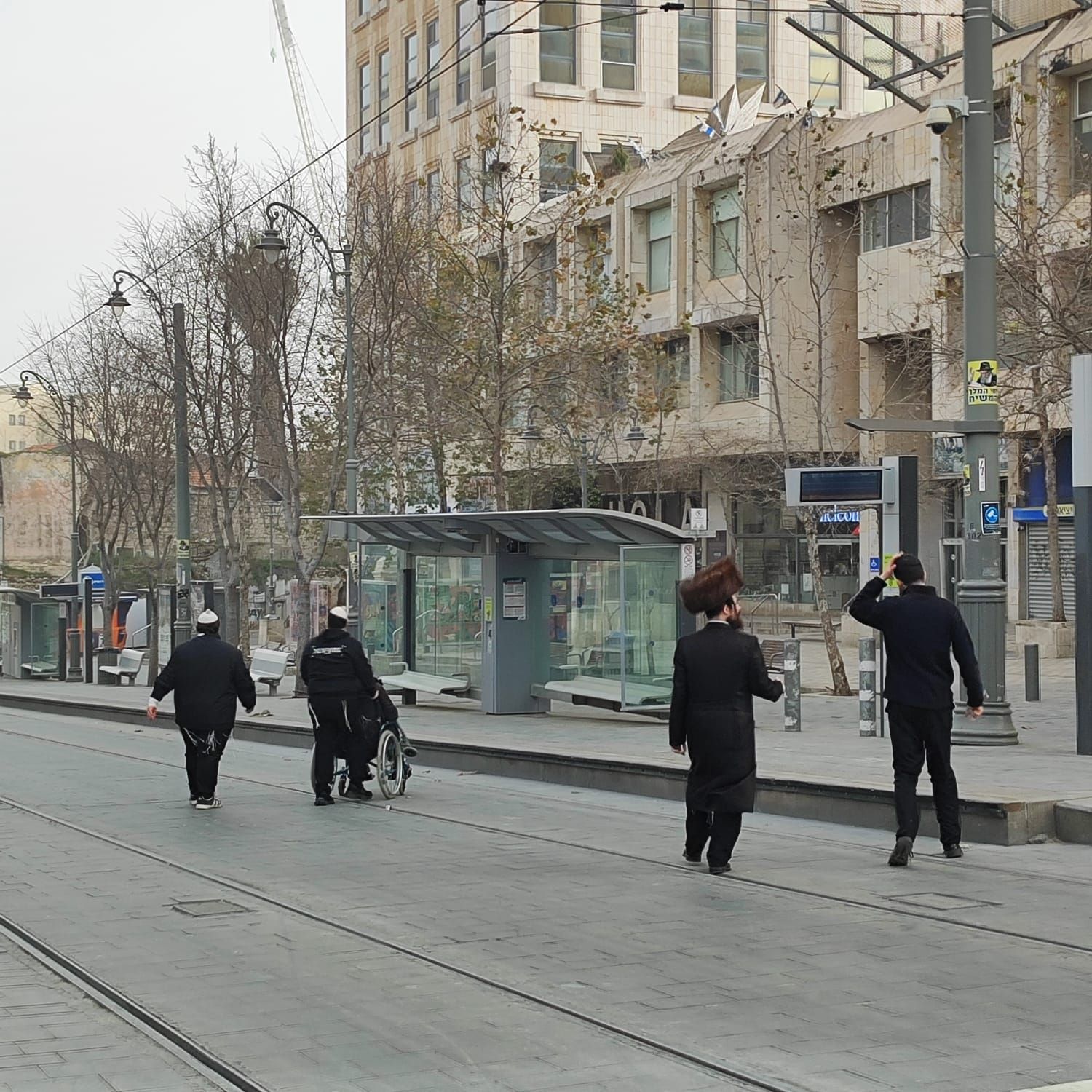 Modernidad y tradición compartiendo el mismo carril. Tranvía, edificios contemporáneos y vestimentas ancestrales. Israel es identidad en movimiento.